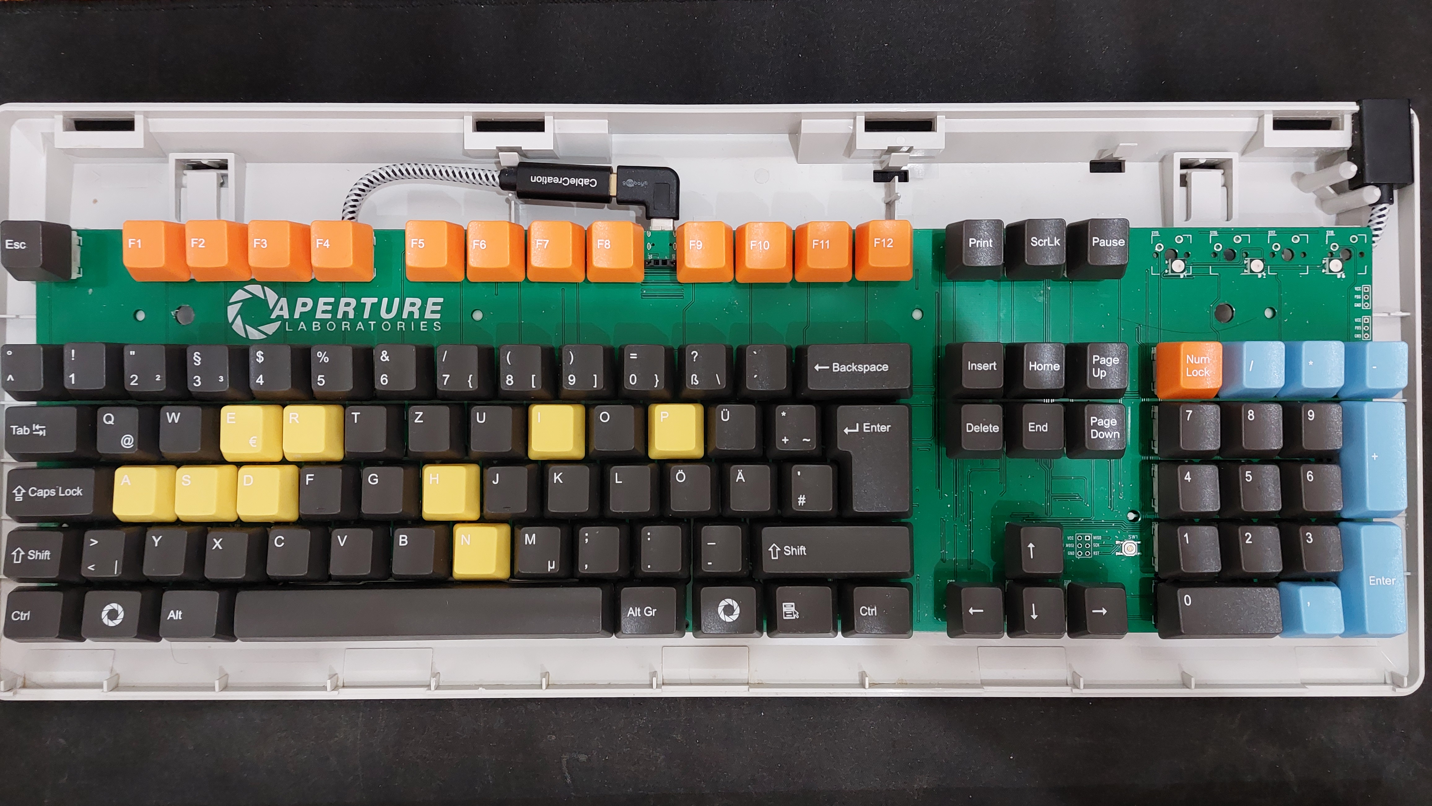 An image of the keyboard without the top cover, exposing the PCB and janky wiring