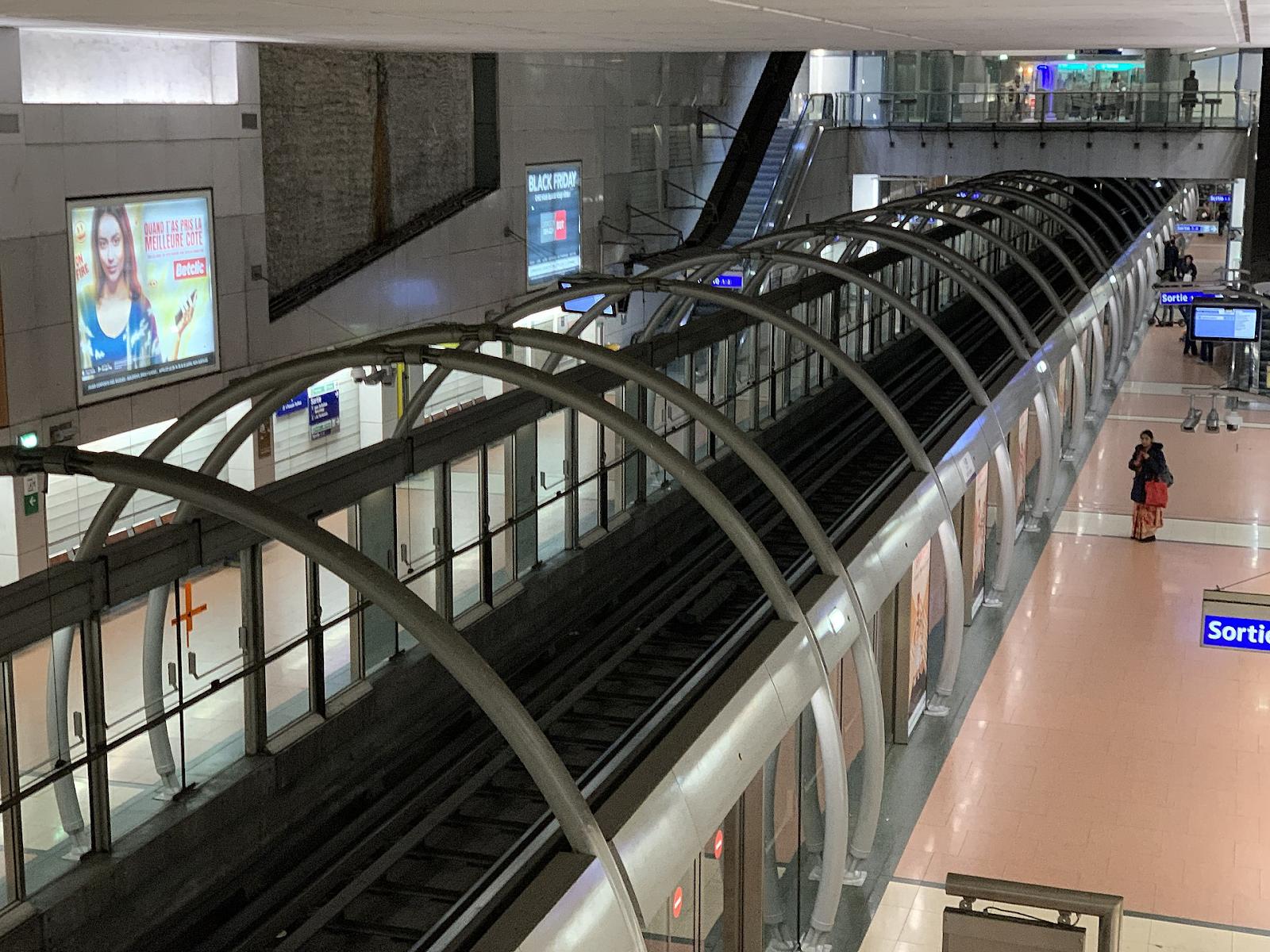 Photo of a modern subway station with platform screen doors separating the platform from the track.